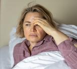 Sick woman lying in bed at home