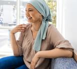 Female cancer patient in clinic lobby chats with unseen friend