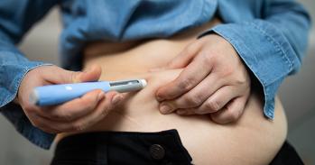 Close-up image of an individual administering a semaglutide injection into their abdomen for weight loss and obesity management