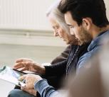 Caretaker and senior woman using digital tablet at nursing home - stock photo