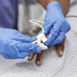 Nurse using pulse oximeter on hospitalised patient