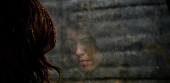 Woman looking at the floor reflected in a window